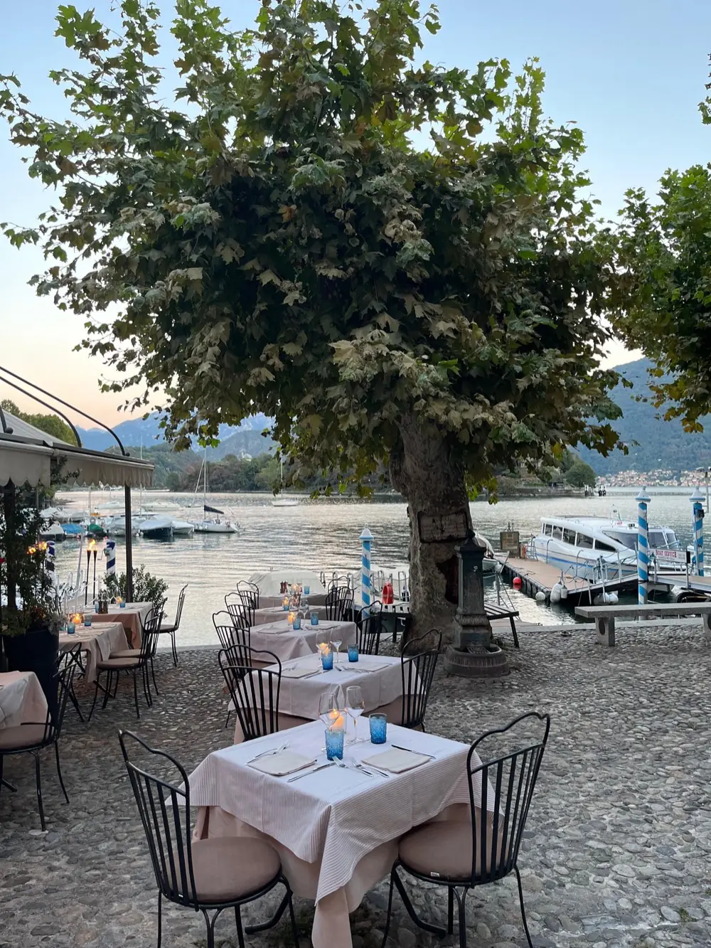 Outdoor tables at La Tirlindana by the lake at sunset